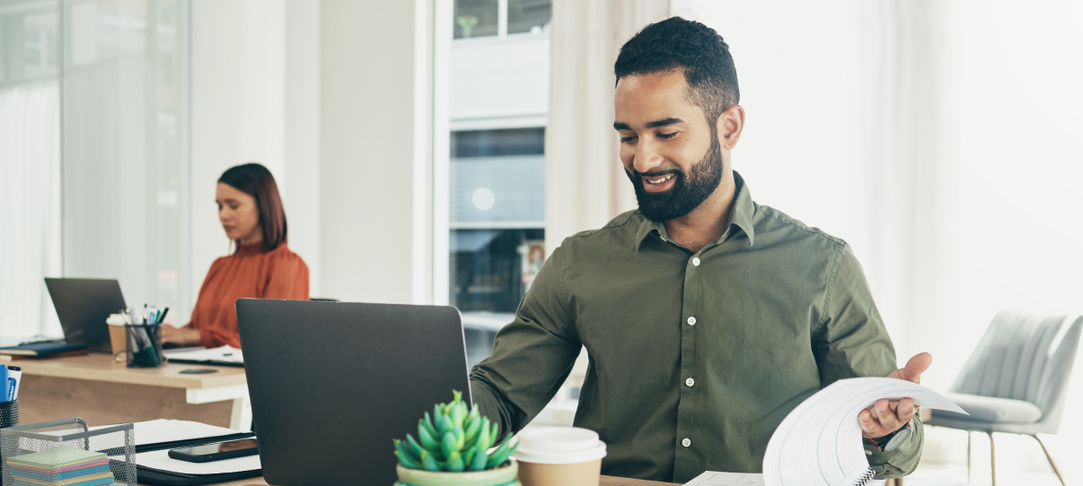 Smiling man reviewing documents at work.